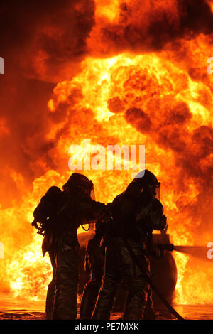 Aircraft Rescue Firefighting Marines extinguish a fuel fire during fuel fire training at Marine Corps Air Station Cherry Point, N.C., Oct. 16, 2015. The training exercise taught the new Marines how to battle the heat and keep pushing until they annihilated the flames, as well as get used to the environment of a real fire. (U.S. Marine Corps photo by Pfc. Nicholas P. Baird/ Released) Stock Photo