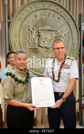 David Ige, Hawaii state governor, and Capt. James Jenkins, Coast Guard 14th District chief of staff, pose for a photo after reading a proclamation announcing the completion of the Anuenue Interisland Digital Microwave Network, at the Hawaii State Capitol in Honolulu, Oct. 22, 2015. The Anuenue IDMN consists of high-capacity microwave links, radio towers, and facility buildings that interconnect and support the systems and networks relied upon by first responders, search and rescue, law enforcement, emergency services, and critical government operations. (U.S. Coast Guard photo by Petty Officer Stock Photo