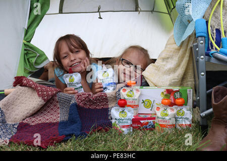 Two girls having fun camping with their Buddy Fruits Stock Photo