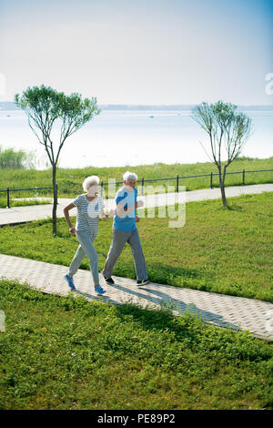 Senior Couple Running in Park Stock Photo