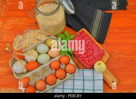 Minced meat, eggs, garlics and onion. Mixed minced meat ready to making burgers, fatty's, meaetballs. Food photography. Culinary concept. Minced meat recipe. Stock Photo