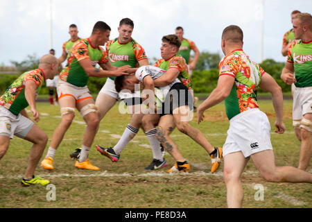 Members of the Camp Kinser Dragons tackle a member of the Camp Hansen Kaiju Rugby Club during a friendly rugby match Oct. 24 aboard Camp Kinser, Okinawa, Japan. In rugby, tackling is the only way to bring down opposing players without receiving a penalty. Once a player is tackled, they must release the ball immediately and attempt to roll the ball to a nearby teammate. The Camp Hansen Kaiju Rugby Club is a Marine Corps Community Services sponsored team that participates in both friendly matches and league games with the Okinawa Rugby Football Union. Stock Photo