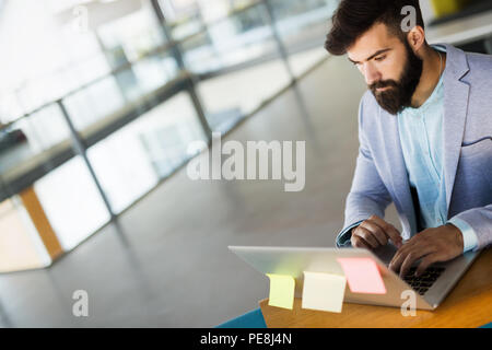 Handsome businessman working on laptop in office Stock Photo