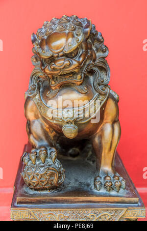 Bronze Chinese lion sculpture, male of the pair, holding a ball, representing the world in his front paw, symbol of protection and power in Asia