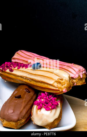 French traditional eclair, decorated with raspberry and cream Stock Photo
