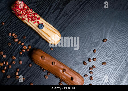 Traditional french coffee eclairs with chocolate, blueberry, raspberry on woodn background Stock Photo
