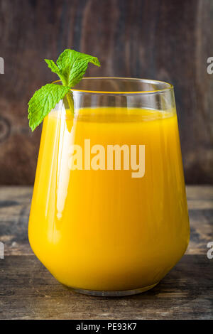 Mango Lassi dessert. Traditional Indian drink on wooden table. Stock Photo