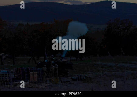 A cloud of smoke can be seen as soldiers from Apache Troop and Charlie Troop 5th Squadron, 7th Cavalry Regiment, stationed at Fort Stewart, Ga., fire a 120mm round out of an M1064A3 Mortar Carrier during a field training exercise in Bulgaria, Nov. 11, 2015. (The 120mm round can be faintly seen as it begins to crest the top of the mountain.) Stock Photo