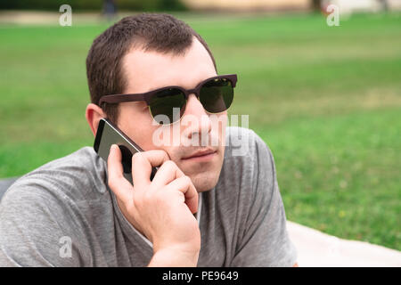Young handsome man using mobile phone in park Stock Photo