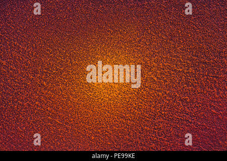 A painted concrete wall in red and orange with a gradient in the center. Texture of rough wallpaper, background. Stock Photo