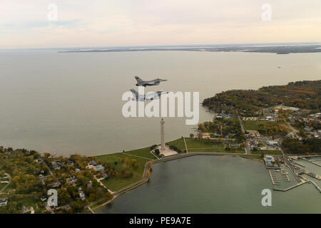 F-16 Fighting Falcons from the 180th Fighter Wing, Ohio Air National Guard, conduct a routine training mission over Perry's Victory and International Peace Memorial in Put-In-Bay, Ohio, Oct. 24, 2015. The 180th FW performs daily training, conducted in realistic environments under realistic circumstances, to ensure our forces maintain the highest levels of proficiency and readiness to defend our nation as the most lethal, innovative and efficient Fighter Wing in the Total Force, both at home and abroad. Stock Photo