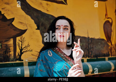 Portrait of beautiful indian brumette girl or hindu woman model against japanese grafiti wall. Stock Photo