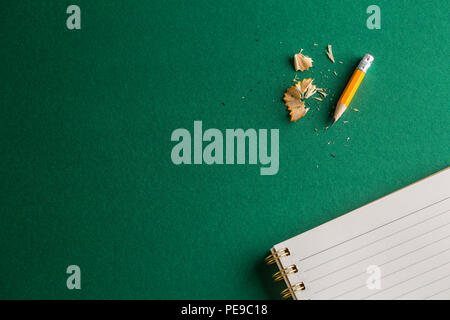 School notebook with pencil on a green background. Stock Photo