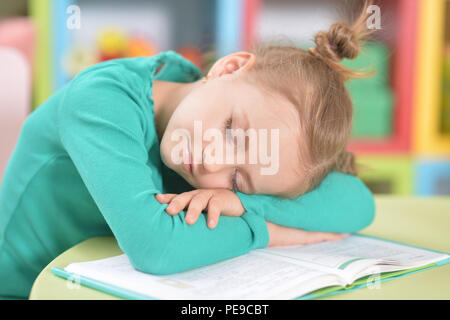 Portrait of cute tired schoolgirl sleeping after studying Stock Photo