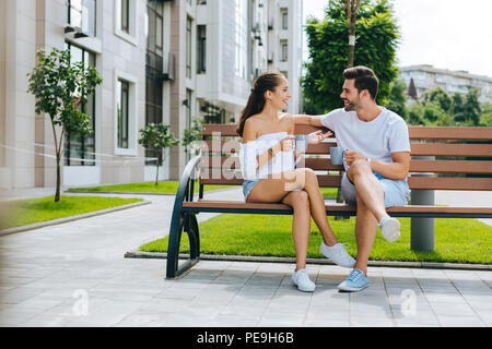 Happy nice people sitting together on the bench Stock Photo