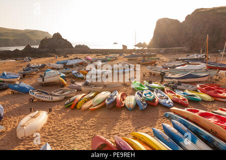 Sea kayaks stacked up on Hope Cove beach, Devon, England, United Kingdom. Stock Photo