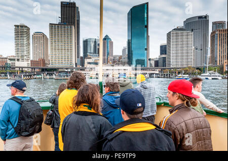 Tourists aboard the iconic Sydney ferry service leave from Circular Quay en route to Manly. Looking back to the stunning skyline of Sydney Harbour. Ne Stock Photo