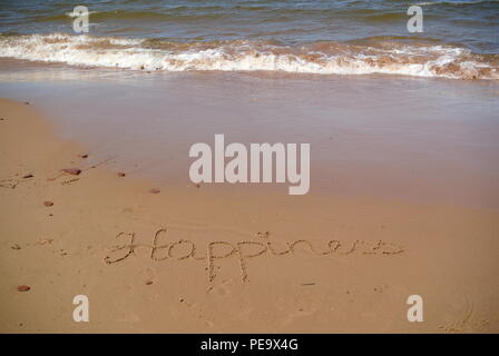 Word "Happiness" beautifully handwritten on red sand on a beach with the sea, sky and waves in the upper part, Prince Edward Island Stock Photo