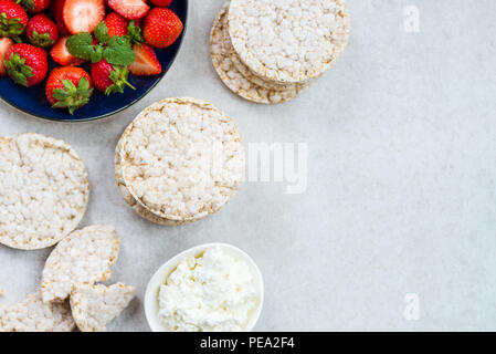 Healthy Snack from Rice Cakes with Ingredients nearby such as Ricotta Cheese and Strawberries on Light Background Stock Photo