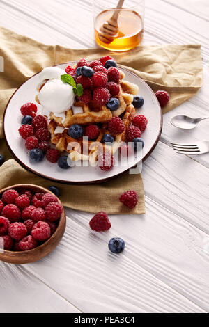 freshly baked belgian waffles with berries on white wooden table Stock Photo