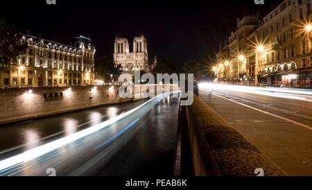 Notre Dame Cathedral of Paris at night with lights trails in the Seine River and the qua d'orleans Stock Photo