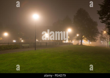 Empty park and streetlights at foggy night Stock Photo