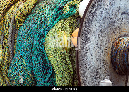 Mixture of colorful fishing nets, floats and ropes with isolated