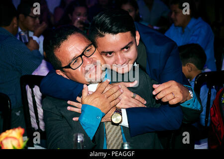 MERIDA, YUC/MEXICO - AUG 25, 2017: Portrait of young man hugging his father, during his university's graduating party Stock Photo