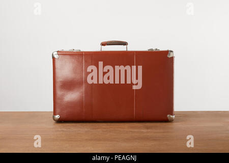 Vintage brown leather suitcase on wooden table Stock Photo