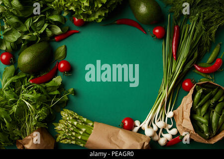 top view of round frame made of various ripe vegetables on green surface Stock Photo