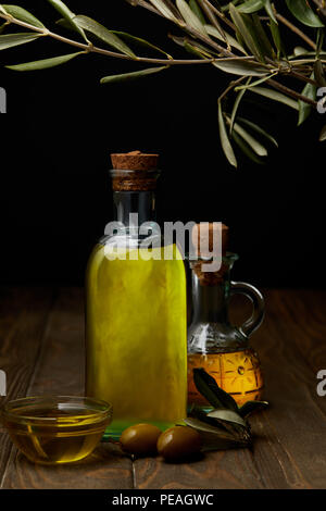 bottles of various olive oil on wooden surface Stock Photo