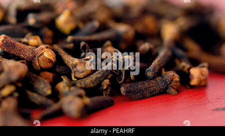 Cloves cooking spices macro closeup. on vintage red wood table, selective focus. Stock Photo