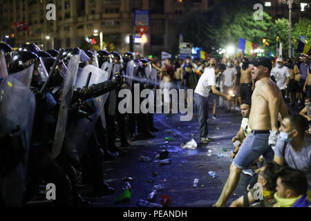 BUCHAREST, ROMANIA - August 10, 2018: Riot police spray teargas while scuffling with protesters outside the government headquarters. Romanians who liv Stock Photo