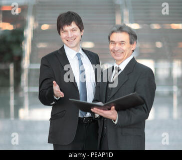 business partners with documents standing in the office. Stock Photo
