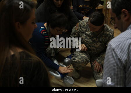 U.S. Army Staff Sgt. Sara Motyka, a Connecticut National Guard Soldier deployed to Kosovo with 1st Battalion, 169th Aviation Regiment, shows PEMA Daycare Center teachers and caregivers how to assess a choking infant, during a Nov. 14, 2015, CPR and first aid class in Pristina, Kosovo. PEMA provides professional social services for children with disabilities as well as educational classes to the parents, families and caregivers. (U.S. Army photo by Sgt. Gina Russell, Multinational Battle Group-East) Stock Photo