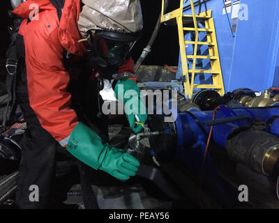 Edward Primeau, an industrial hygienist with the Coast Guard Atlantic Strike Team,  collects a sample of water product mixture that was pumped from the sunken barge Argo during lighting operations, Nov. 24, 2015. Samples are collected while the product is being removed to identify the contents of the barge’s tanks. (U.S. Coast Guard photo by Kurt Kollar, Ohio EPA) Stock Photo