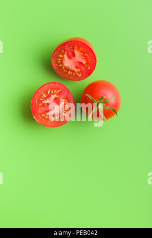 Tasty red tomatoes on green background. Stock Photo
