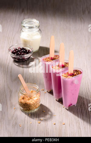 Sweet fruit Popsicles in molds with cooking ingredients on wooden background Stock Photo