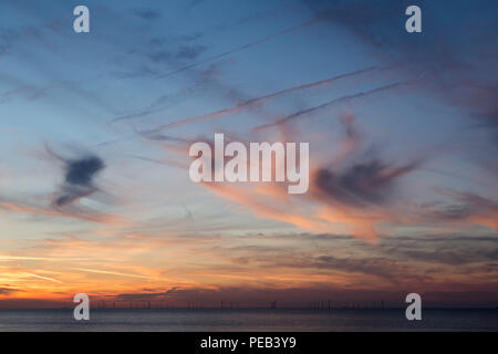 A squiggly sky at sunset from Reculver, Kent, UK looking across the Thames Estuary towards the Kentish Flats wind farm. Stock Photo