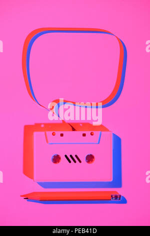 toned pink picture of pencil and retro audio cassette with speech bubble Stock Photo