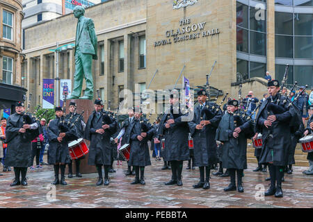 Glasgow, UK. 14th Aug 2018. Rain didn't stop play for the Brisbane Boys College Pipe Band from Australia who entertained the public by playing in rain showers in Buchanan Street, Glasgow. The World Pipe Band Championships are on Saturday 18 August with Pipe bands from around the world competing for the title Credit: Findlay/Alamy Live News Stock Photo