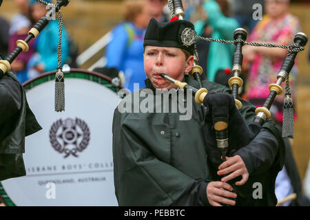 Glasgow, UK. 14th Aug 2018. Rain didn't stop play for the Brisbane Boys College Pipe Band from Australia who entertained the public by playing in rain showers in Buchanan Street, Glasgow. The World Pipe Band Championships are on Saturday 18 August with Pipe bands from around the world competing for the title. Liam Docherty from Brisbane is one of the pipers Credit: Findlay/Alamy Live News Stock Photo