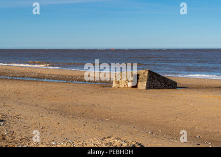 North sea coast in Caister-on-Sea, Norfolk, England, UK -  with an old bunker on the beach Stock Photo