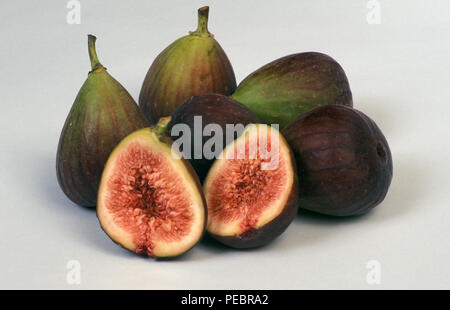 STUDIO IMAGE OF WHOLE AND HALVED FIGS (FICUS CARICA) ON WHITE BACKGROUND. Stock Photo