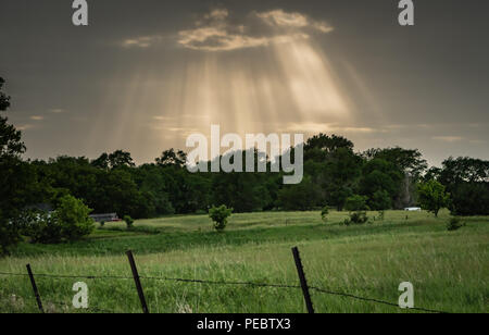 Rays Burst Through Storm Clouds Over Pasture Stock Photo
