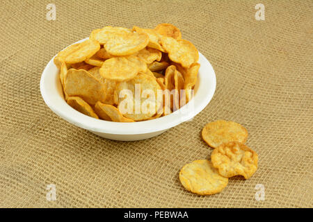 Healthy alternative of crispy healthy hummus and basil chips in eco-friendly disposable white fiber bowl Stock Photo