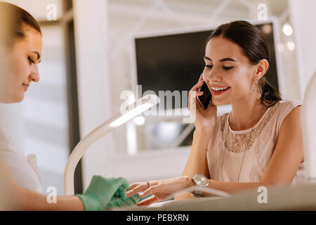 Stylish woman wearing beige blouse having nice manicure Stock Photo