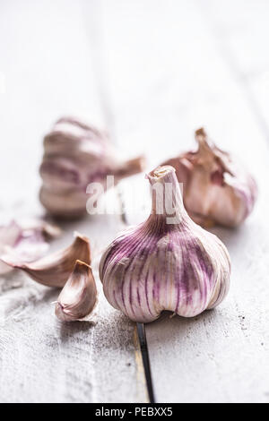 Garlic cloves and bulbs on vintage wooden table. Stock Photo
