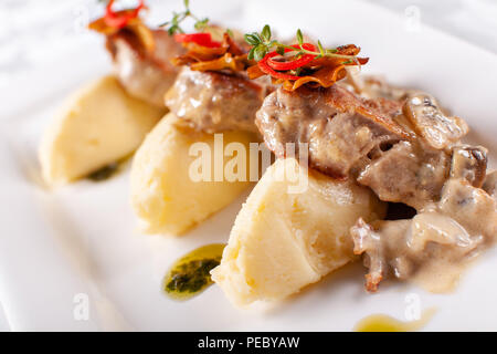 Pork Medallions with Mashed Potato and Mushrooms. Pork tenderloin on a white plate, good serving. restaurant menu Stock Photo