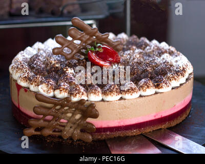 Cheesecake pie with raspberries, decorated with fresh strawberries, on black background Stock Photo